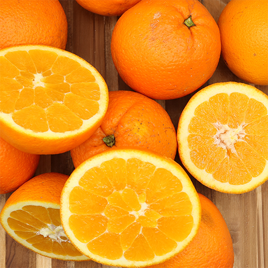 Fresh Algarve oranges, whole and halved, showcasing their juicy, sun-drenched pulp. Naturally grown without chemicals, available in a 10 KG pack with 10% free.