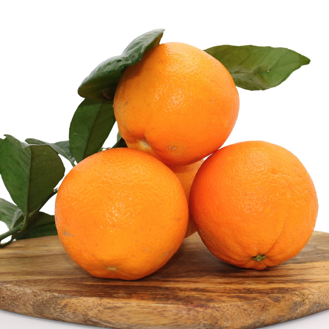 Fresh Algarve oranges 10 KG + 10% FREE, naturally grown without chemicals. Sweet, juicy citrus fruits with green leaves on a wooden board.