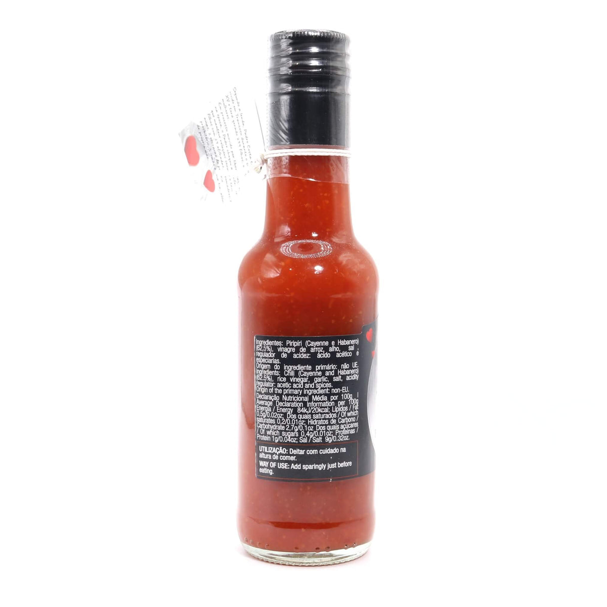 A bottle of red hot sauce with a black cap, shown from the back against a plain white background.