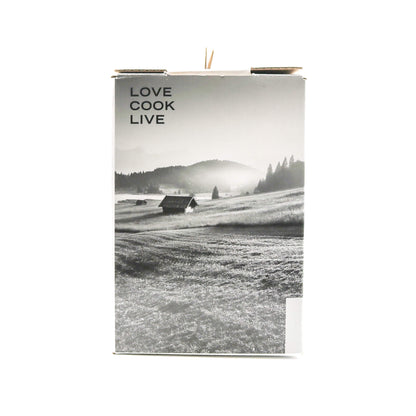 Side of box for citrus press with words 'Love Cook Live' with a black and white landscape on the cover