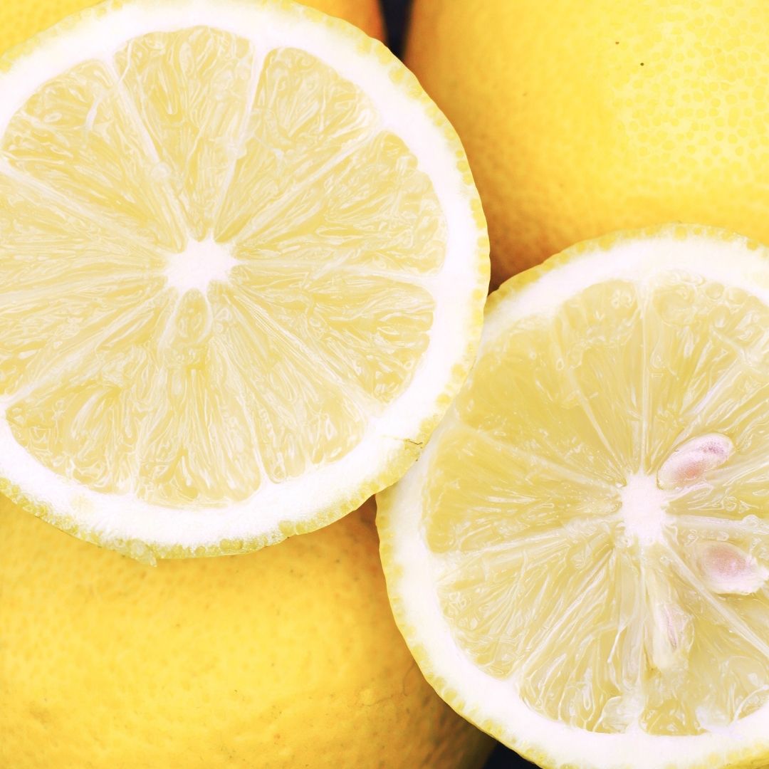 Close-up of sliced lemons with whole lemons in the background