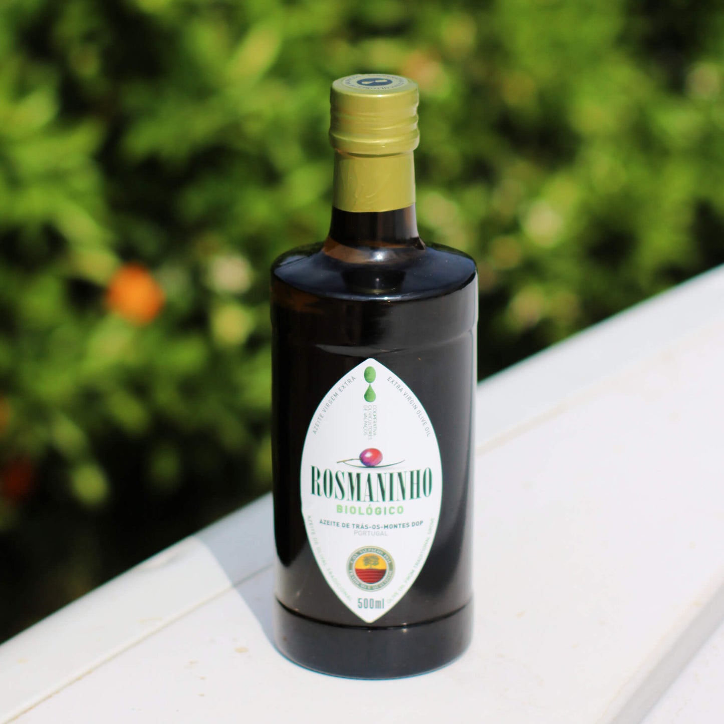 Bottle of Rosmanzano on a white surface with a blurred green background