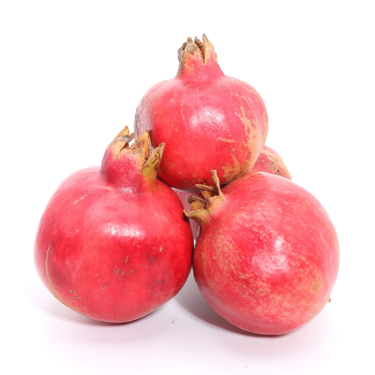 pile of whole fresh pomegranates on white background