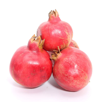 pile of whole fresh pomegranates on white background